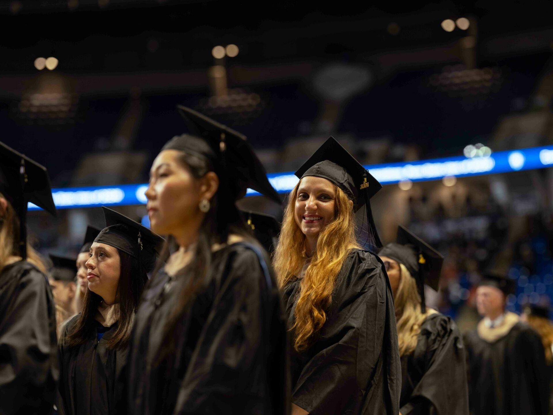 Student smiling in the crowd during Spring Commencement