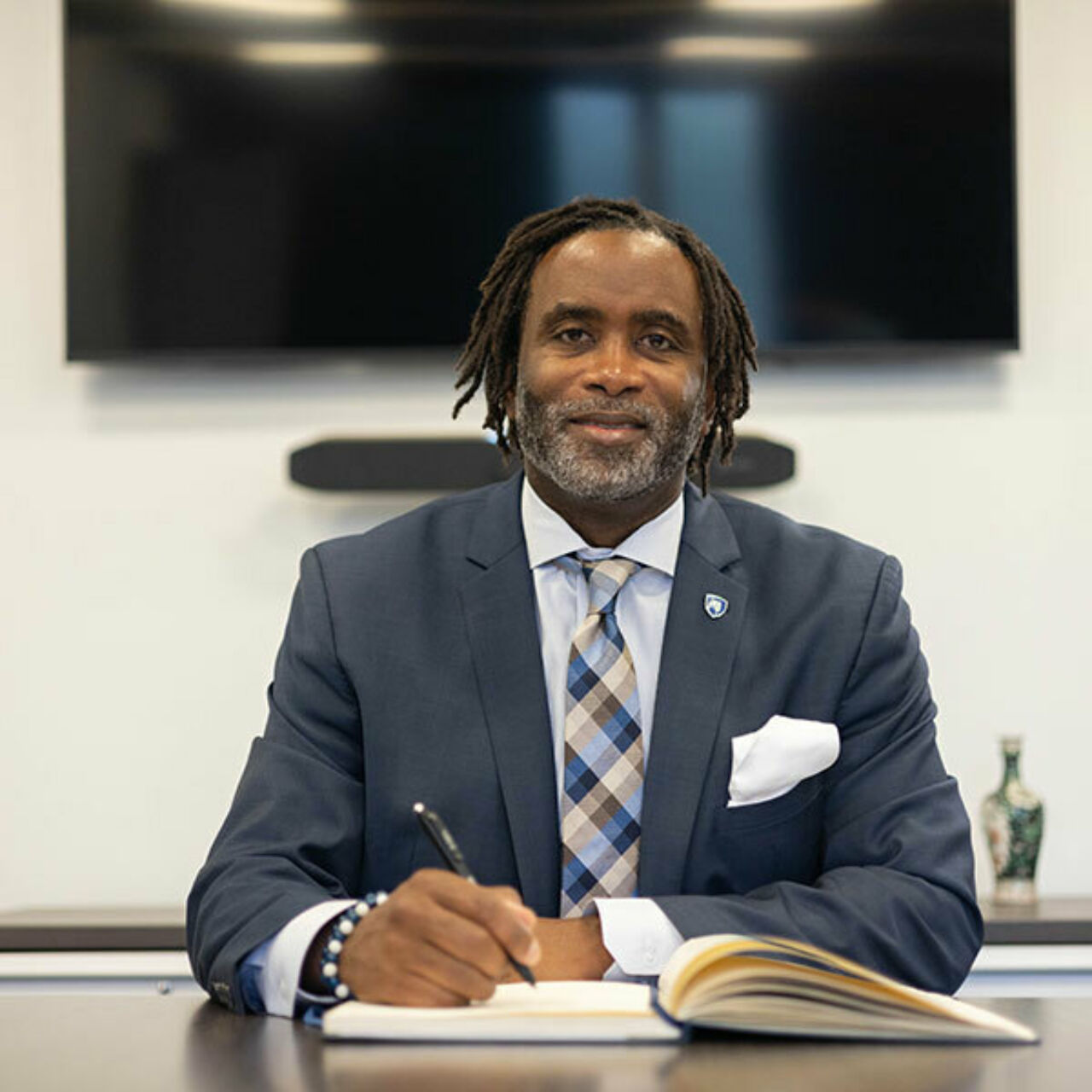 Dean Levon Esters seated at desk with open book.