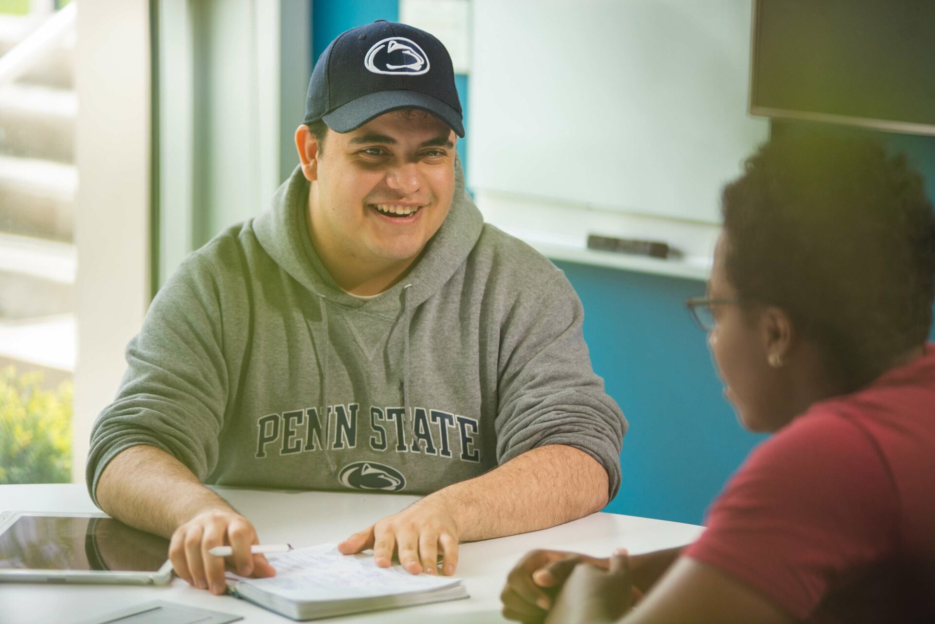 Two students talking at a classroom table