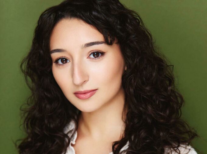 Head shot of a young woman with dark, wavy hair.